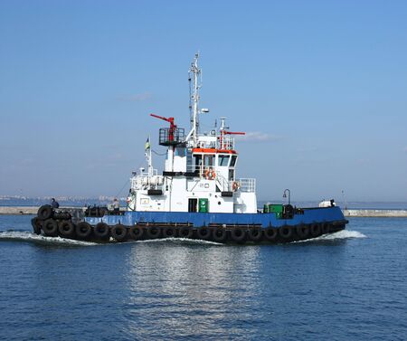moving tugboat out at sea with a perfect blur sky.