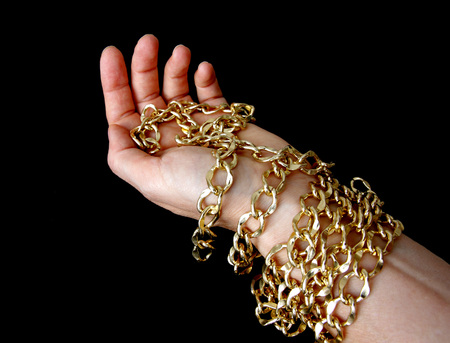 golden chain in hand, black backgroundの写真素材
