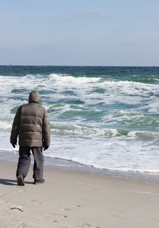 man walking alone near the seaの写真素材