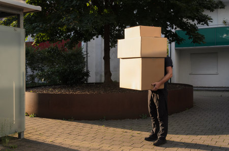 Delivery man holds the big boxes.の写真素材