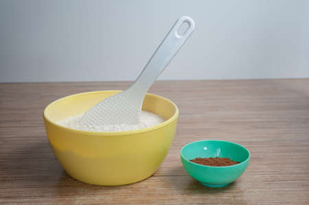 bowls of flour and cocoa are on the kitchen table