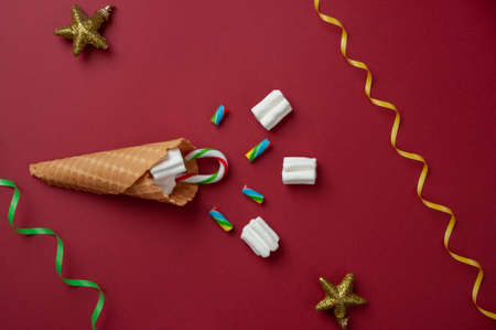 new year card: waffle cone with marshmallows, candy and Christmas toysの写真素材