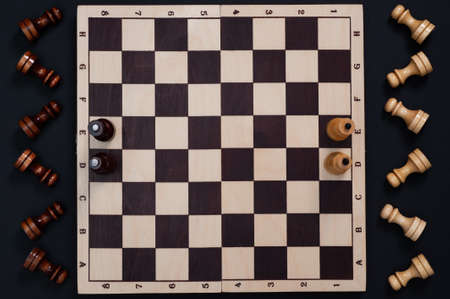 chessboard with figures on a black background, top view