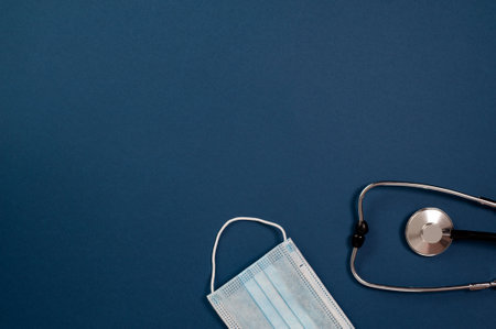 stethoscope and mask on blue background with place for text, top viewの写真素材