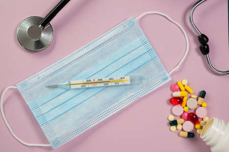medicines, mask and medical instruments are on the table