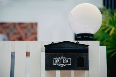 Black mailbox hanging on the fenceの写真素材