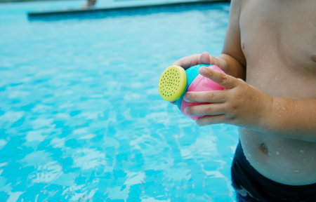 Boy playing in the swimming pool with a toy. Selective focus.の写真素材