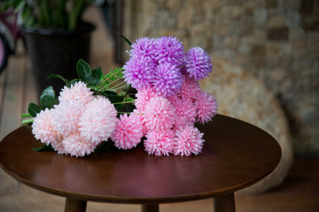 A bouquet of pink and purple aster flowers on a wooden tableの写真素材
