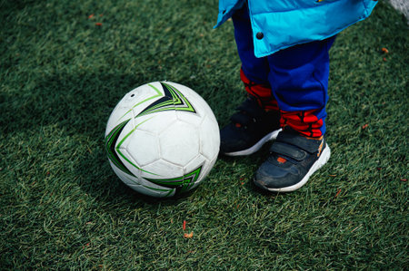 Soccer player kicking the ball on the green field, close-upの写真素材