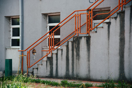 staircase of an old building with an orange metal railing.の写真素材