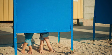 man and woman hiding behind a blue metal curtainの写真素材