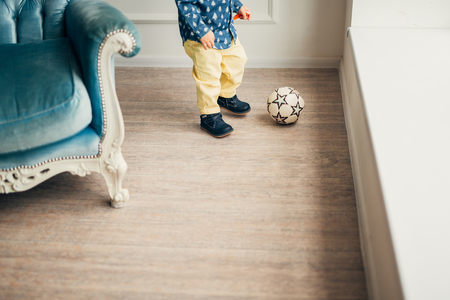 The legs of a small child playing with a ball.の写真素材