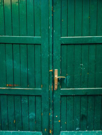 Green doors. Wood texture. Old shabby, irradiated paint. Old wooden doorsの写真素材