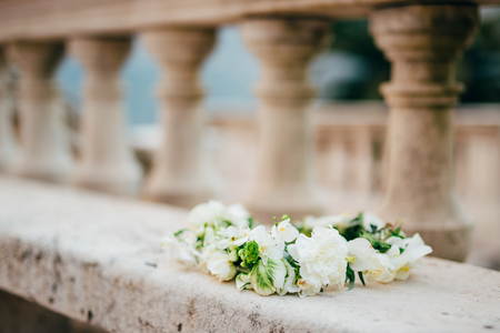 Wreath Bride of white flowers on old stone bench.の写真素材