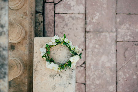 Wreath Bride of white flowers on old stone bench.の写真素材