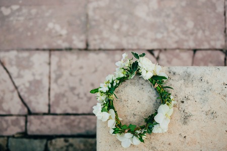 Wreath Bride of white flowers on old stone bench.の写真素材