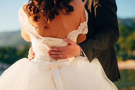 The groom embraces the bride on the beach. Wedding in Montenegro and Croatia.の写真素材