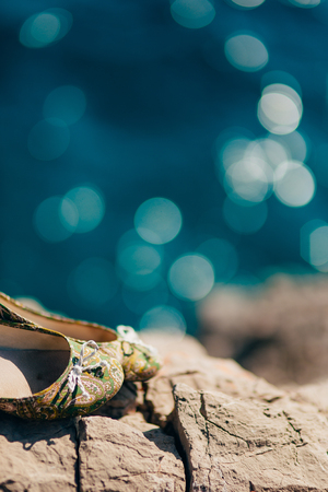 Wedding shoes on the rocks by the sea. Bride Clothing.の写真素材
