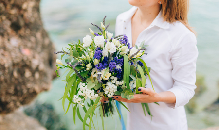 Wedding bridal bouquet of roses, lisianthus, lavender, Gypsophila, Verdure Italian in the hands of the bride. Wedding in Croatia, Dubrovnik.の写真素材