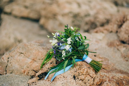 Wedding bridal bouquet of roses, lisianthus, lavender, Gypsophila, Verdure Italian on the rocks. Wedding in Croatia, Dubrovnik.の写真素材