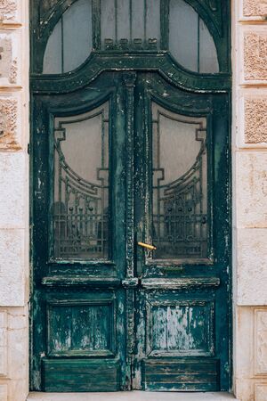 Green doors. Wood texture. Old shabby, irradiated paint. Old wooden doorsの写真素材