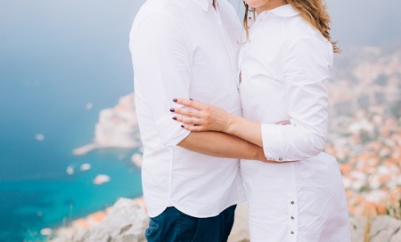 The newlyweds hold hands on a viewing platform over Dubrovnik. Couple holding hands. Wedding in Croatia.の写真素材