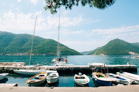 The old town of Perast on the shore of Kotor Bay, Montenegro. The ancient architecture of the Adriatic and the Balkans. Boats and yachts on the dock.の写真素材