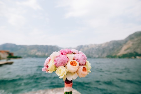 Bridal bouquet of roses and peonies on the background of water. Bay of Kotor, Montenegro.の写真素材