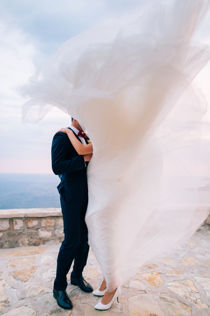 Bride and groom in the wind. Dress develops in the wind.の写真素材