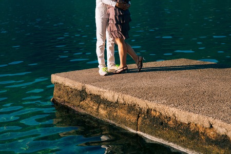 Newlyweds on the quay. Legs close-up. Wedding in Montenegro.の写真素材