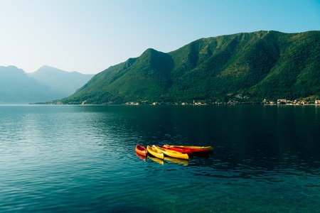 Kayaks moored in the water. Empty kayaks without people. In the Bay of Kotor, in Montenegro.の写真素材