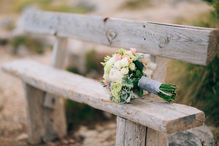 Wedding bridal bouquet of Lisianthus and Cineraria Silver on an old wooden bench handmade. Wedding in Montenegro, Adriatic.の写真素材