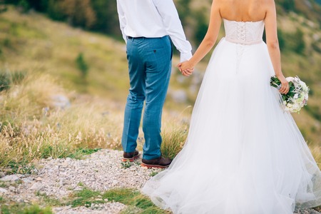 Couple holding hands in the mountains. Newlyweds in the mountains holding hands. Wedding in Montenegro.の写真素材