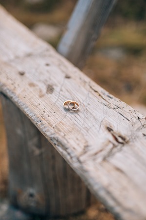 Wedding rings on a light wooden texture. Wedding jewelry.の写真素材