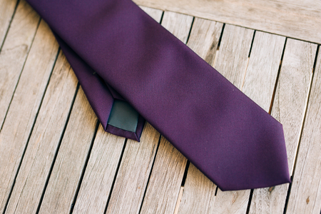 Purple tie on wooden background. Close-up wooden texture.の写真素材