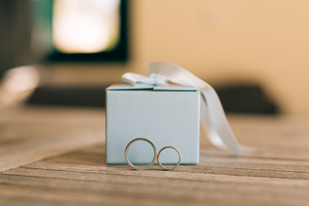 Wedding rings on a light wooden texture in a blue box. Wedding jewelry.の写真素材