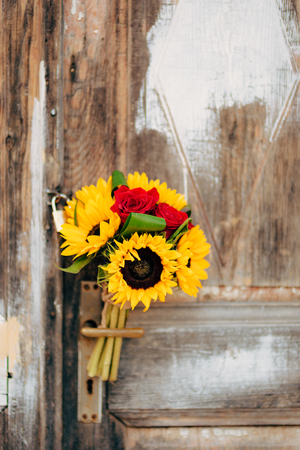 Wedding bridal bouquet of sunflowers on a background of white and gray shabby door. Wedding in Montenegro, Perast.の写真素材