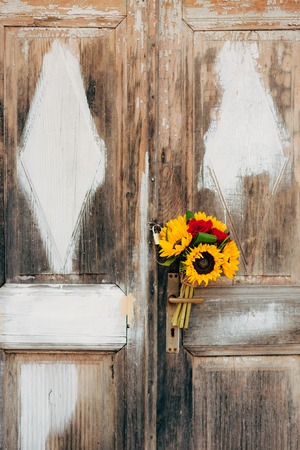 Wedding bridal bouquet of sunflowers on a background of white and gray shabby door. Wedding in Montenegro, Perast.の写真素材