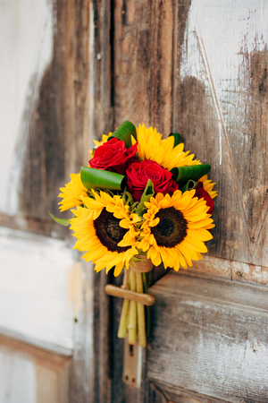 Wedding bridal bouquet of sunflowers on a background of white and gray shabby door. Wedding in Montenegro, Perast.の写真素材