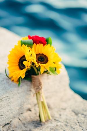 Wedding bridal bouquet of sunflowers on the dock near the sea. Wedding in Montenegro, Perast.の写真素材