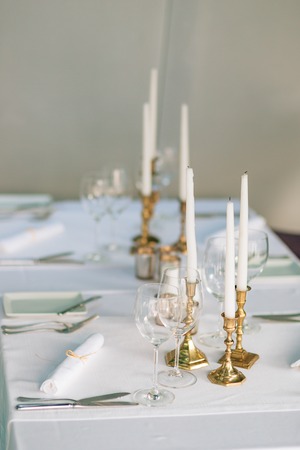 Candles on the table in the restaurant. Table setting in a cafe. Romantic dinner.の写真素材