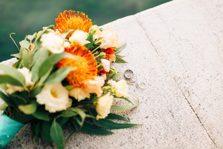 Wedding rings and bunch of Proteus, Verdure Italian , Lisianthus on the stone steps. Wedding jewelry.の写真素材