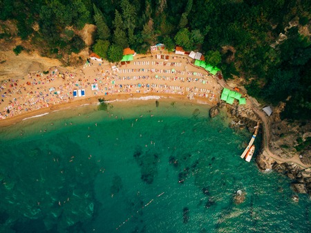 Top View of Beach. Aerial view of sandy beach with tourists swimming in beautiful clear sea water. People on the beach.の写真素材