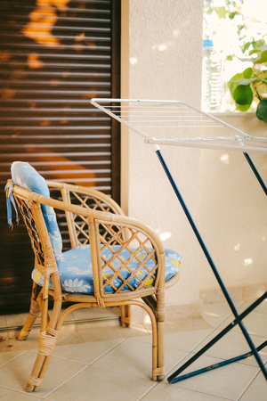 Wicker chair with a blue pillow on the terrace.の写真素材
