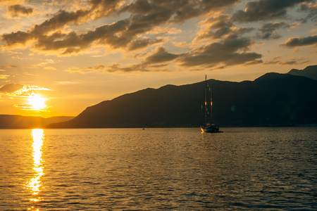 Yacht in the sea at sunset. Silhouette of a yacht on the background of the setting sun on the horizonの写真素材