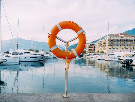 Lifebuoy in the marina for yachts. Red circle on the boat dock. Porto Montenegro, Montenegro.の写真素材