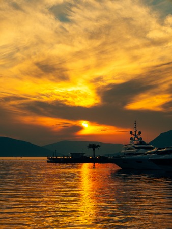 Yacht in the sea at sunset. Silhouette of a yacht on the background of the setting sun on the horizonの写真素材