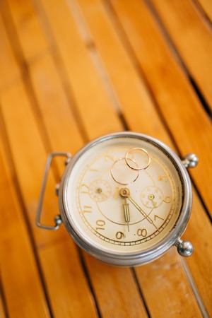Wedding rings on an old mechanical alarm clock.の写真素材