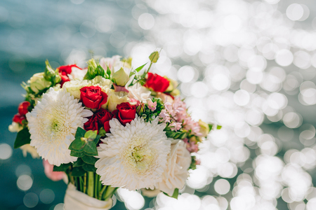 Bridal bouquet of roses and chrysanthemums on a background texture of water. Bay of Kotor, Montenegro.の写真素材