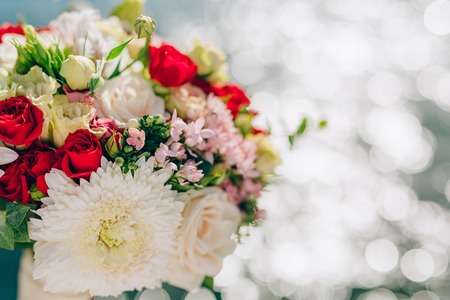 Bridal bouquet of roses and chrysanthemums on a background texture of water. Bay of Kotor,...